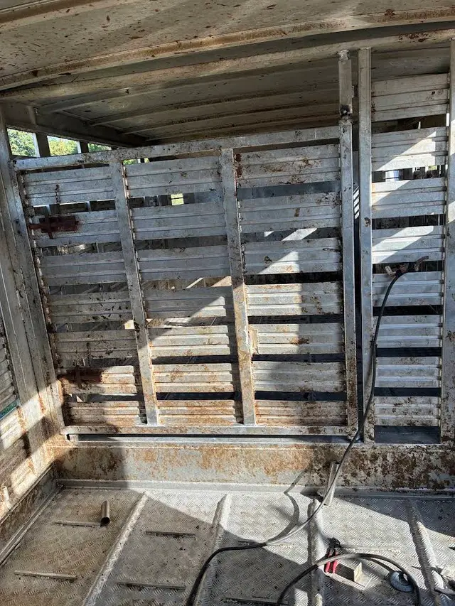 Interior of a metal trailer with welded panels and repair tools